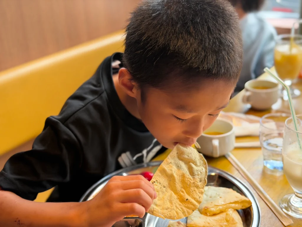 インドカレー店MINAで大きなナンとカレーを楽しむにこにこスイッチの子どもたち