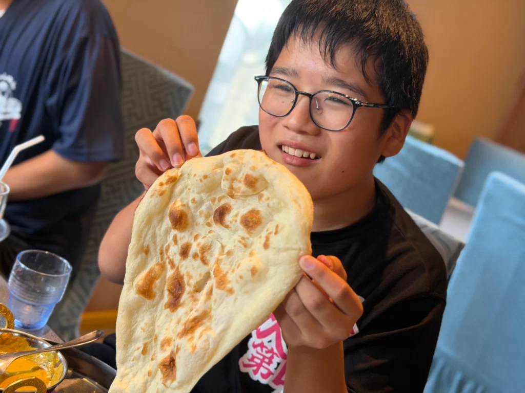 インドカレー店MINAで大きなナンとカレーを楽しむにこにこスイッチの子どもたち