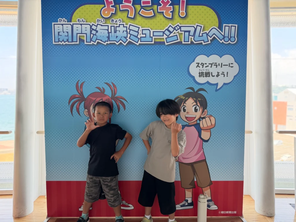 関門海峡ミュージアムのパネルの前でポーズを取る子どもたち