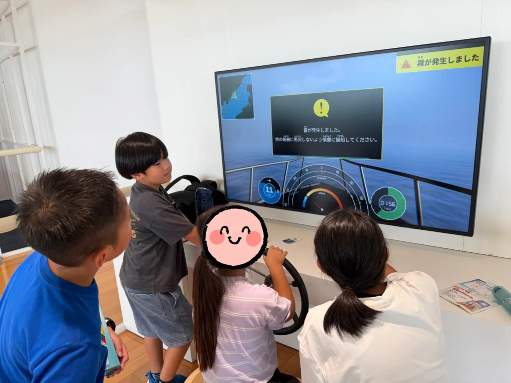 関門海峡ミュージアムで船の操作を体験するゲームをプレイする子どもたち