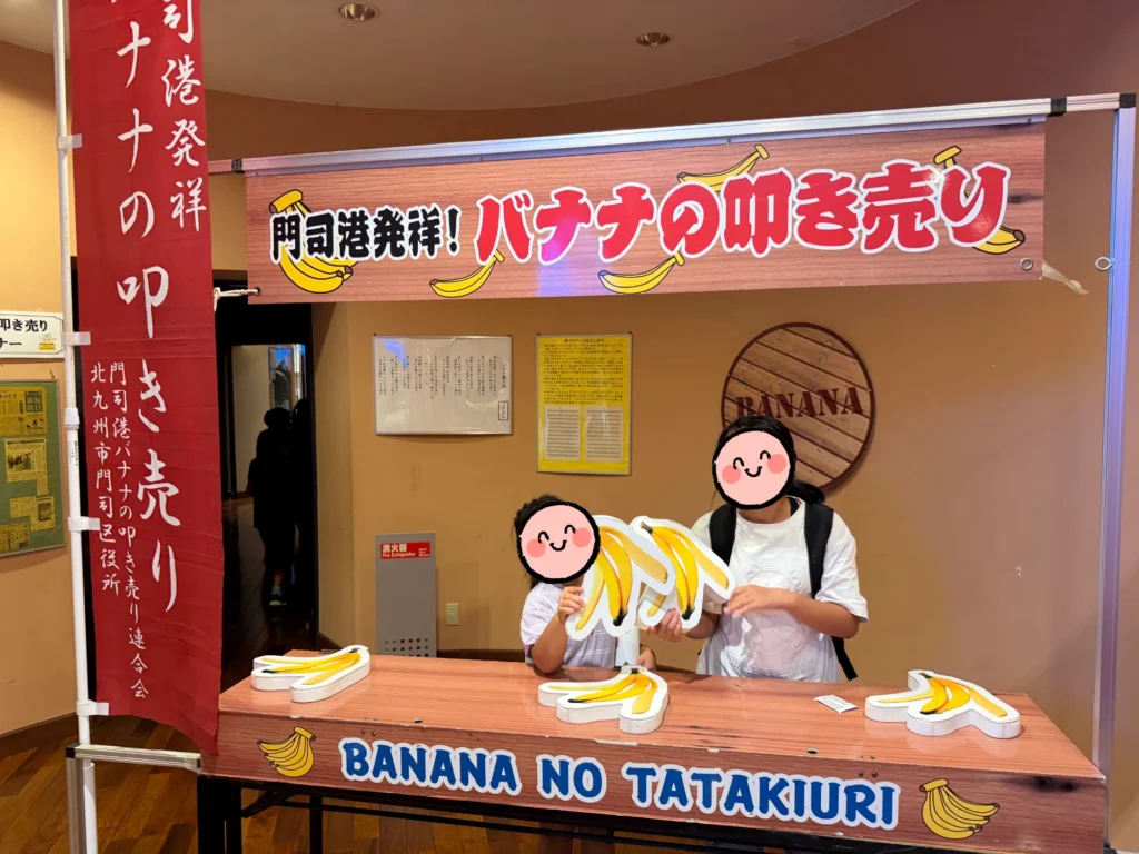 関門海峡ミュージアムのバナナ資料館でバナナの叩き売りの記念写真を撮る子どもたち