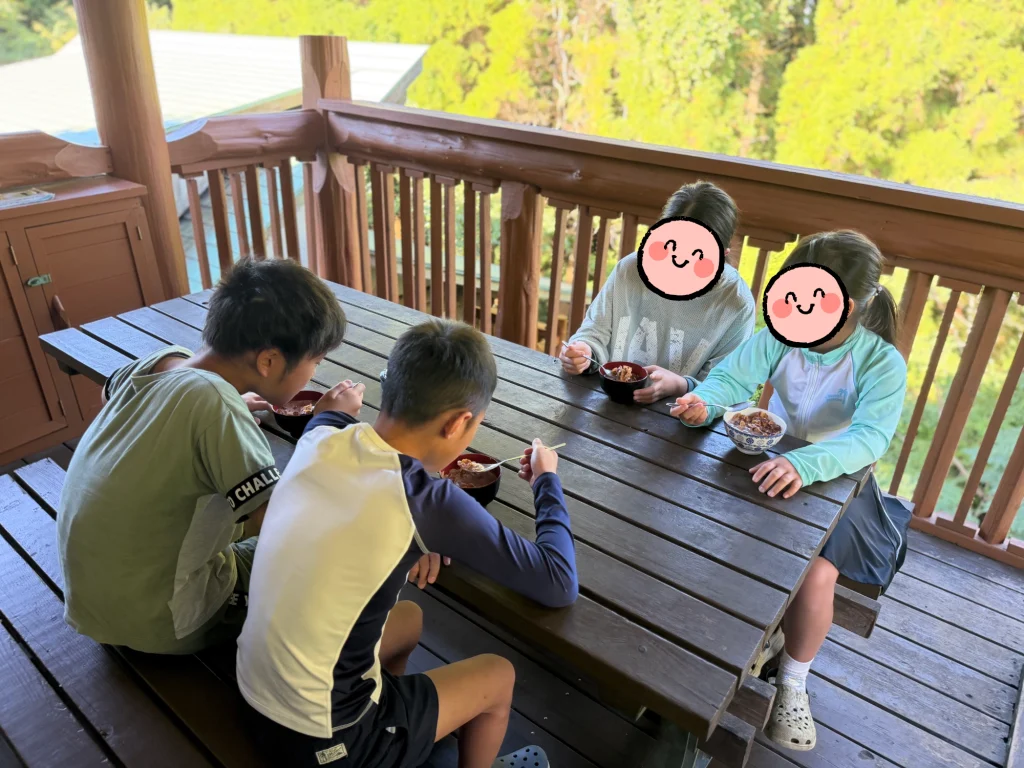 キャンプで朝食にシリアルを食べる子どもたち