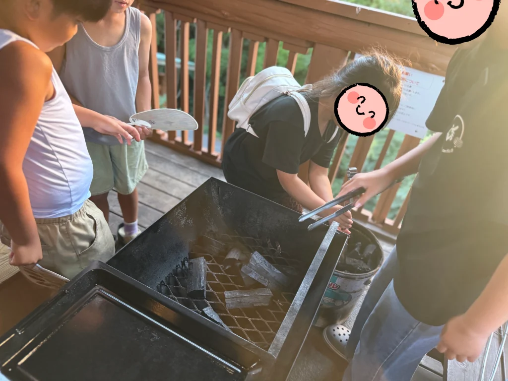 キャンプでバーベキューの準備をする子どもたち