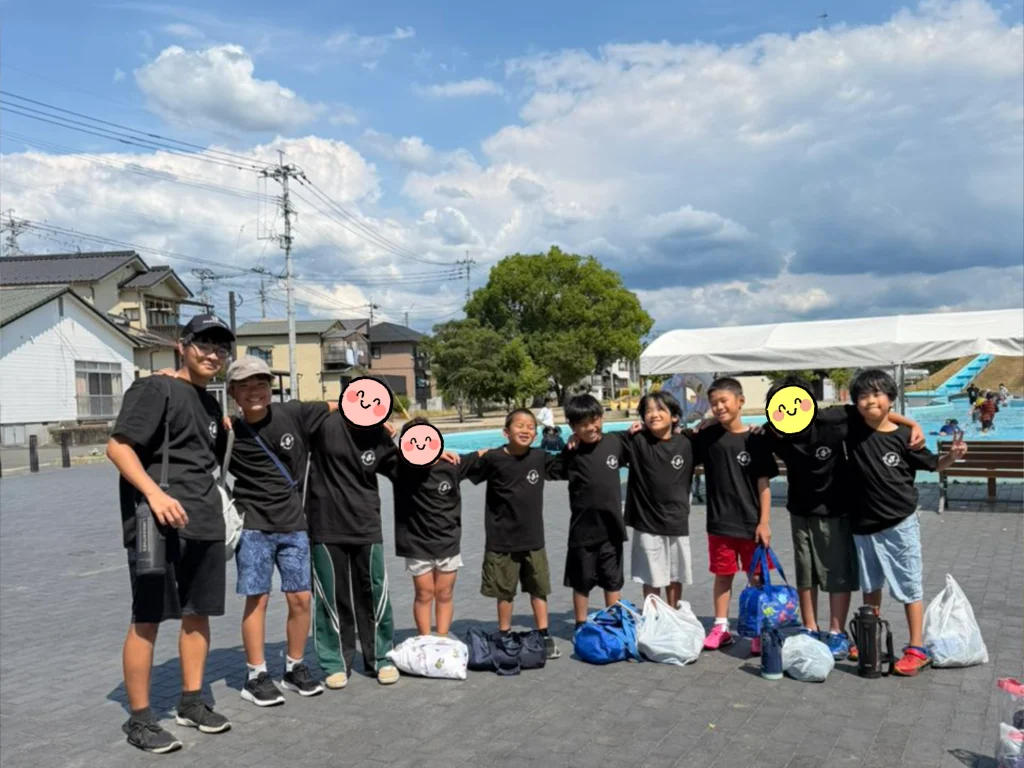 竹田公園せせらぎ水路で集合写真を撮る子どもたち