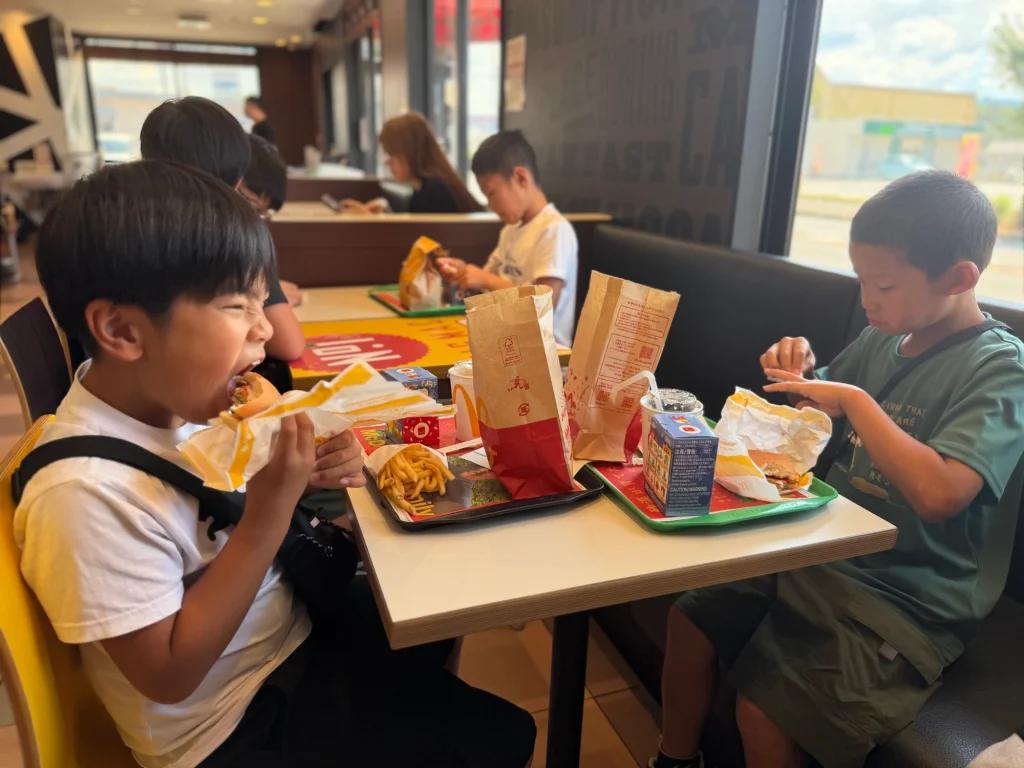 夏合宿1日目に日田のマクドナルドで昼食を食べる子どもたち