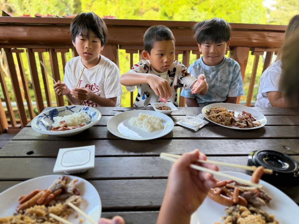 コテージを朝食を摂る子どもたち
