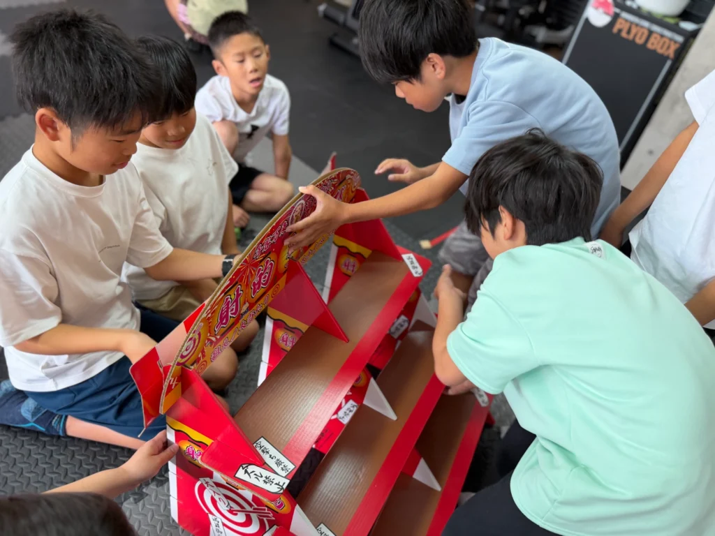 射的の台を組み立てる子どもたち