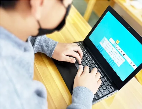 画面を見ながらノートパソコンのキーボードを操作する手元