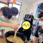 麻婆豆腐作りで木べらを使って鍋の中を混ぜる子どもたち