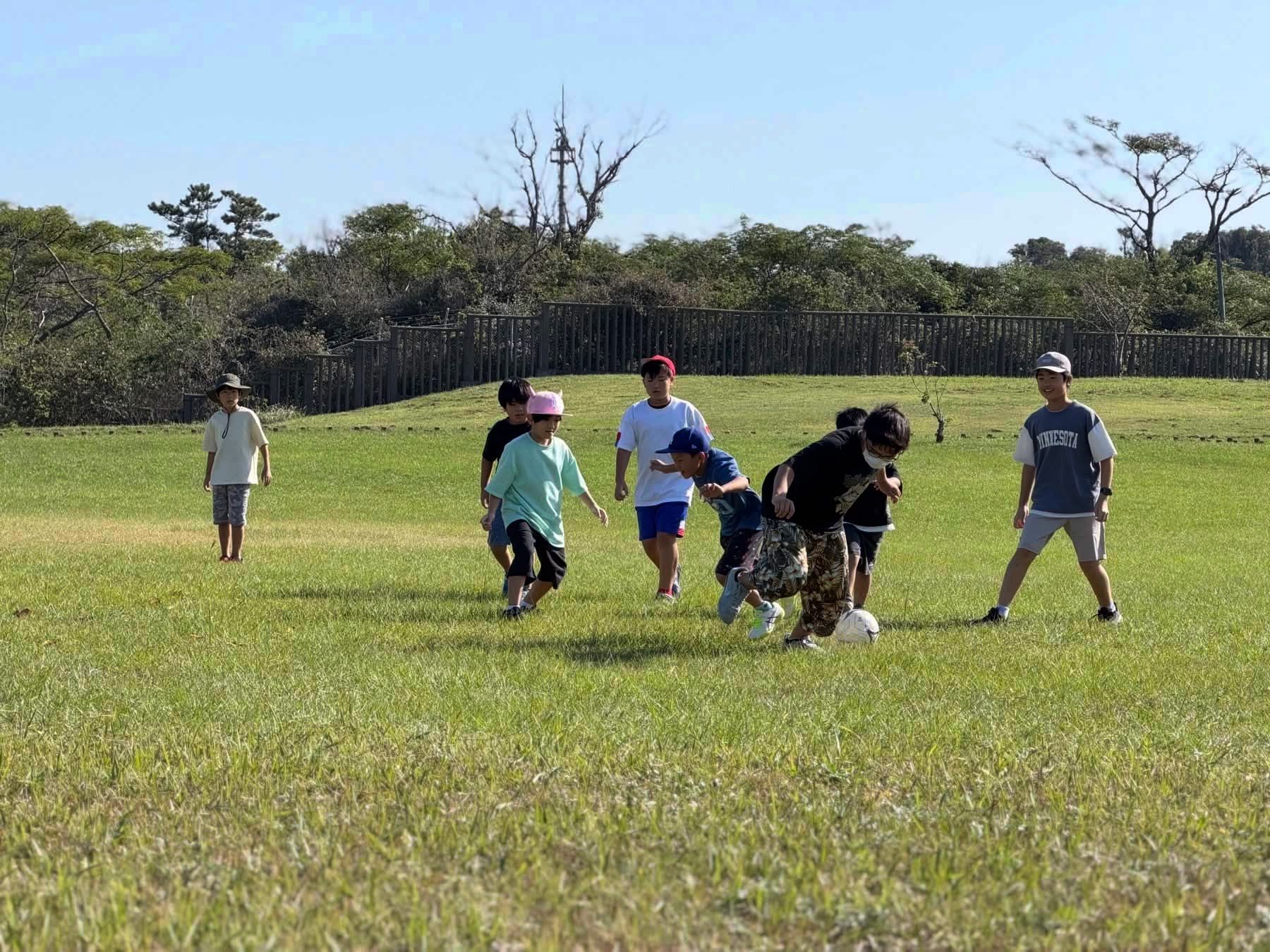 わんぱーくの芝生の広場でサッカーをする子どもたち